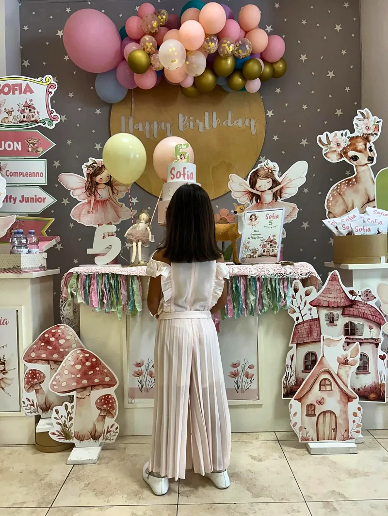 Una bambina davanti all'allestimento a tema fatine, tra funghetti e casette