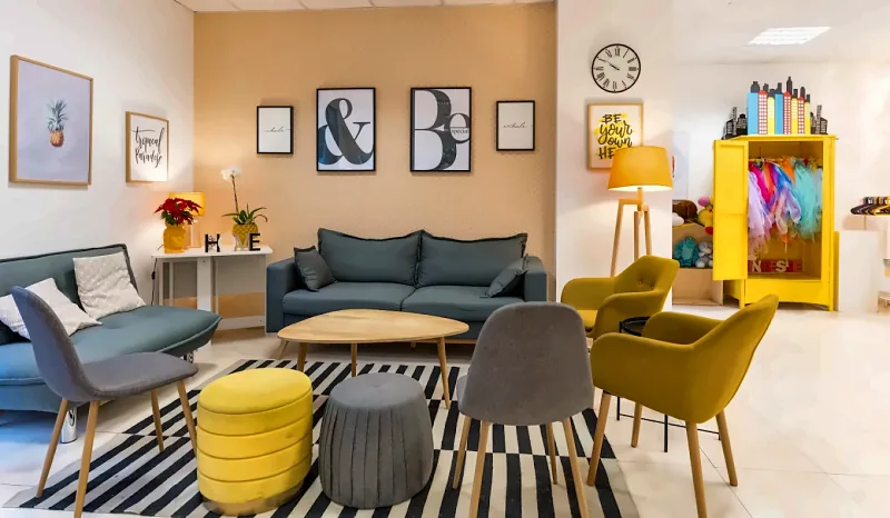 Il salotto del locale, con divani, poltroncine gialle e l'armadio dei travestimenti